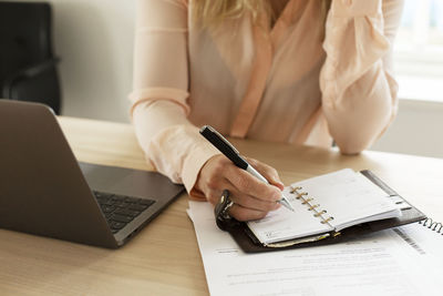 Woman making notes in diary