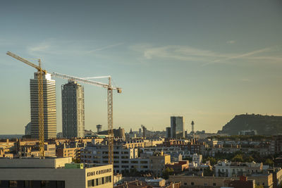 Construction site by buildings against sky in city