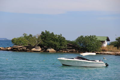 Sailboat on rock by sea against sky