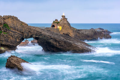 Scenic view of cliff against stormy ocean in biarritz south west of france after sunset