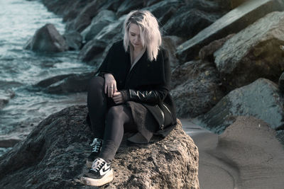 Woman sitting on rock at beach