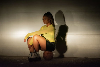 Full length of woman sitting on wall