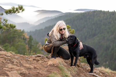 Full length of woman with dog on land