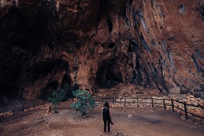 Rear view of people walking on rock formations