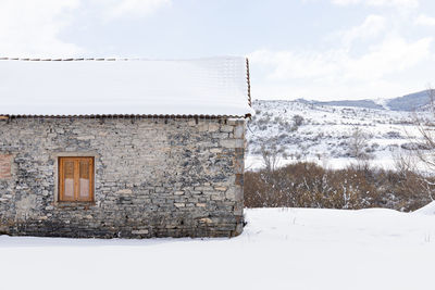 House on field against sky during winter