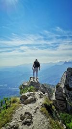 Rear view of man on rock against sky