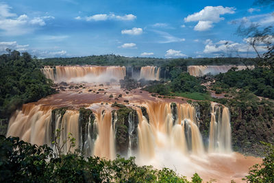 Scenic view of waterfall against sky