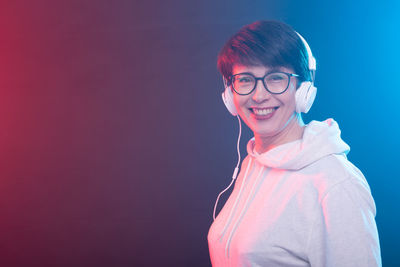 Young woman standing against blue background