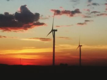 Low angle view of silhouette wind turbine against sky during sunset