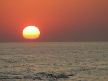 Scenic view of sea against orange sky