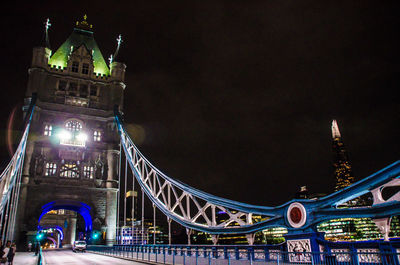 Low angle view of illuminated bridge against sky at night