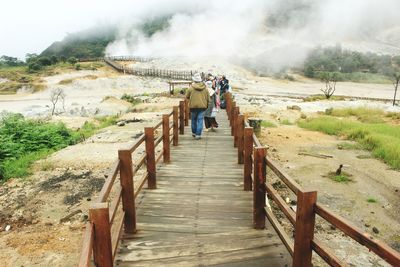 Rear view of people walking on mountain