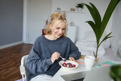 Portrait of young woman sitting on table