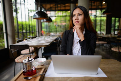 Businesswoman using laptop while sitting at restaurant