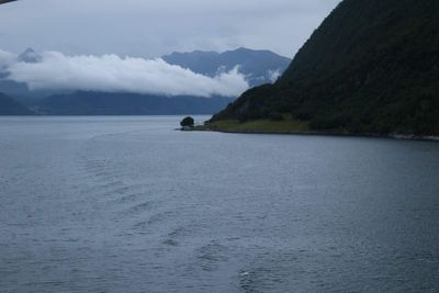 Scenic view of sea and mountains against sky