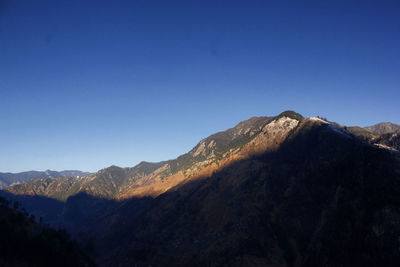 Scenic view of mountains against clear blue sky