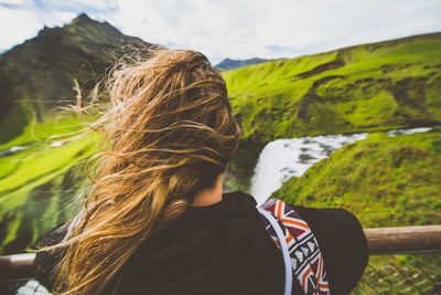 Rear view of woman on mountain against sky