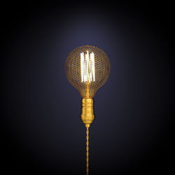 Close-up of illuminated light bulb against black background