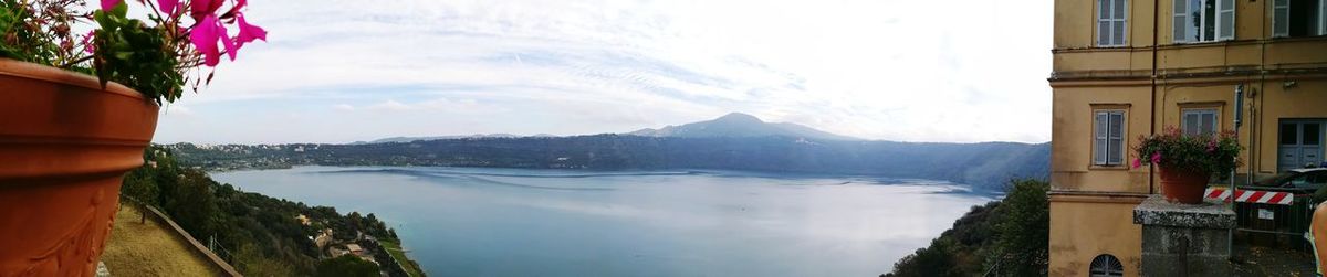 Panoramic view of lake by buildings against sky