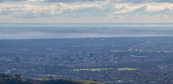 High angle view of townscape by sea against sky