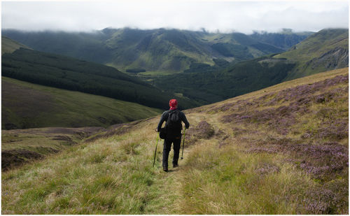 Hiker descends into glen clova, angus.