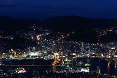 Illuminated cityscape against sky at night