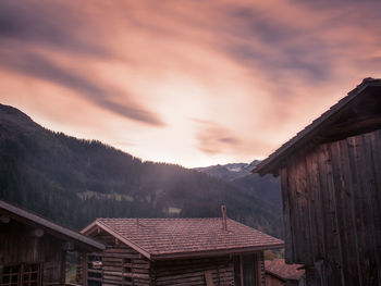 Houses on mountain against sky during sunset