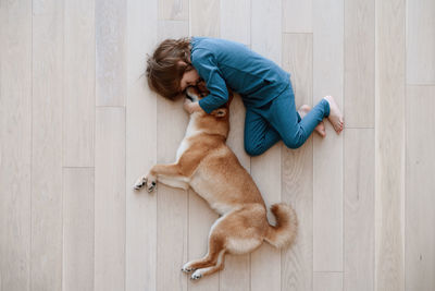 High angle view of cat relaxing on wooden floor