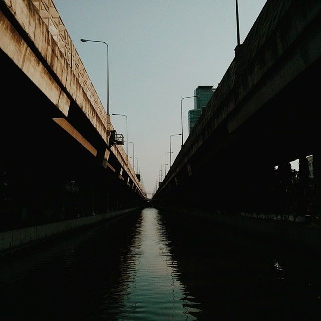 architecture, built structure, connection, building exterior, diminishing perspective, the way forward, clear sky, bridge - man made structure, water, transportation, waterfront, long, canal, vanishing point, river, bridge, sky, city, outdoors, narrow