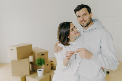 Portrait of man with woman holding house keys at home