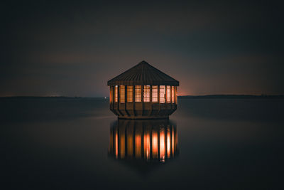 Lifeguard hut on beach against sky during sunset