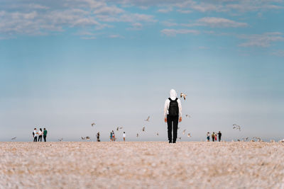 People on beach against sky