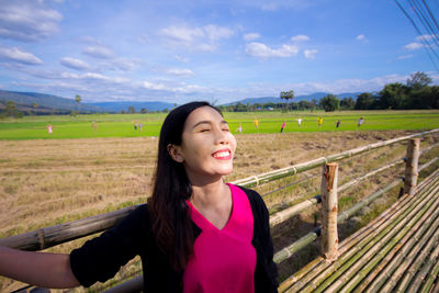 Portrait of a smiling young woman on field