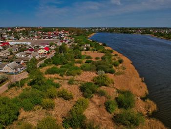 High angle view of townscape by sea against sky