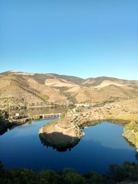 Scenic view of lake against clear blue sky