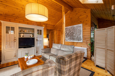 Beautiful interior of cozy living room with sofa and armchairs in a wooden house. life in a village