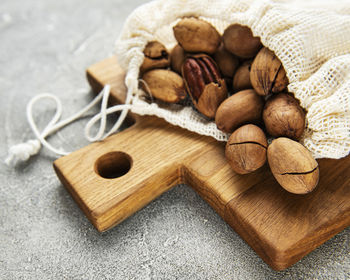 Pecan nuts in cotton bag on a grey concrete background