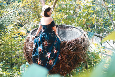 Portrait of woman sitting in wicker container