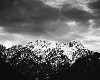 Low angle view of snowcapped mountains against sky