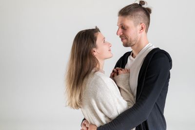 Side view of couple standing against white background