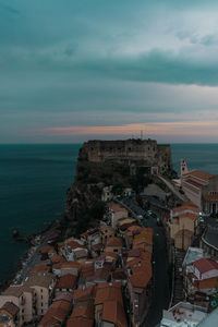 High angle view of townscape by sea against sky