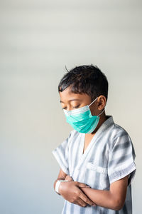 Portrait of young man standing against white background