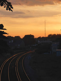 High angle view of railroad tracks on field against cloudy sky at sunset