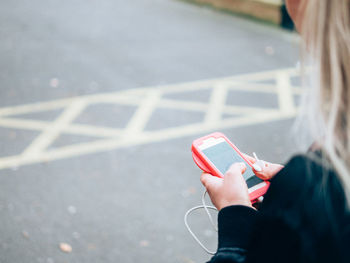 Woman using mobile phone on road