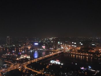 Illuminated cityscape against sky at night