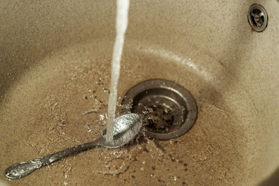 High angle view of faucet in water