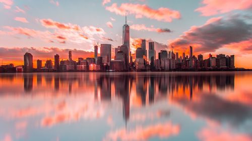 Reflection of buildings in city at sunset