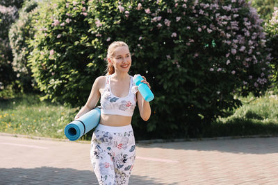 Happy fun healthy athletic girl in sportswear training and exercising in the park in nature outdoors