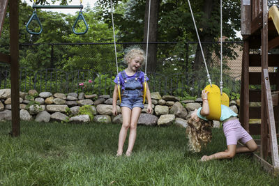 Happy sisters swinging at playground