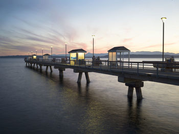 Pier over sea against sky during sunset